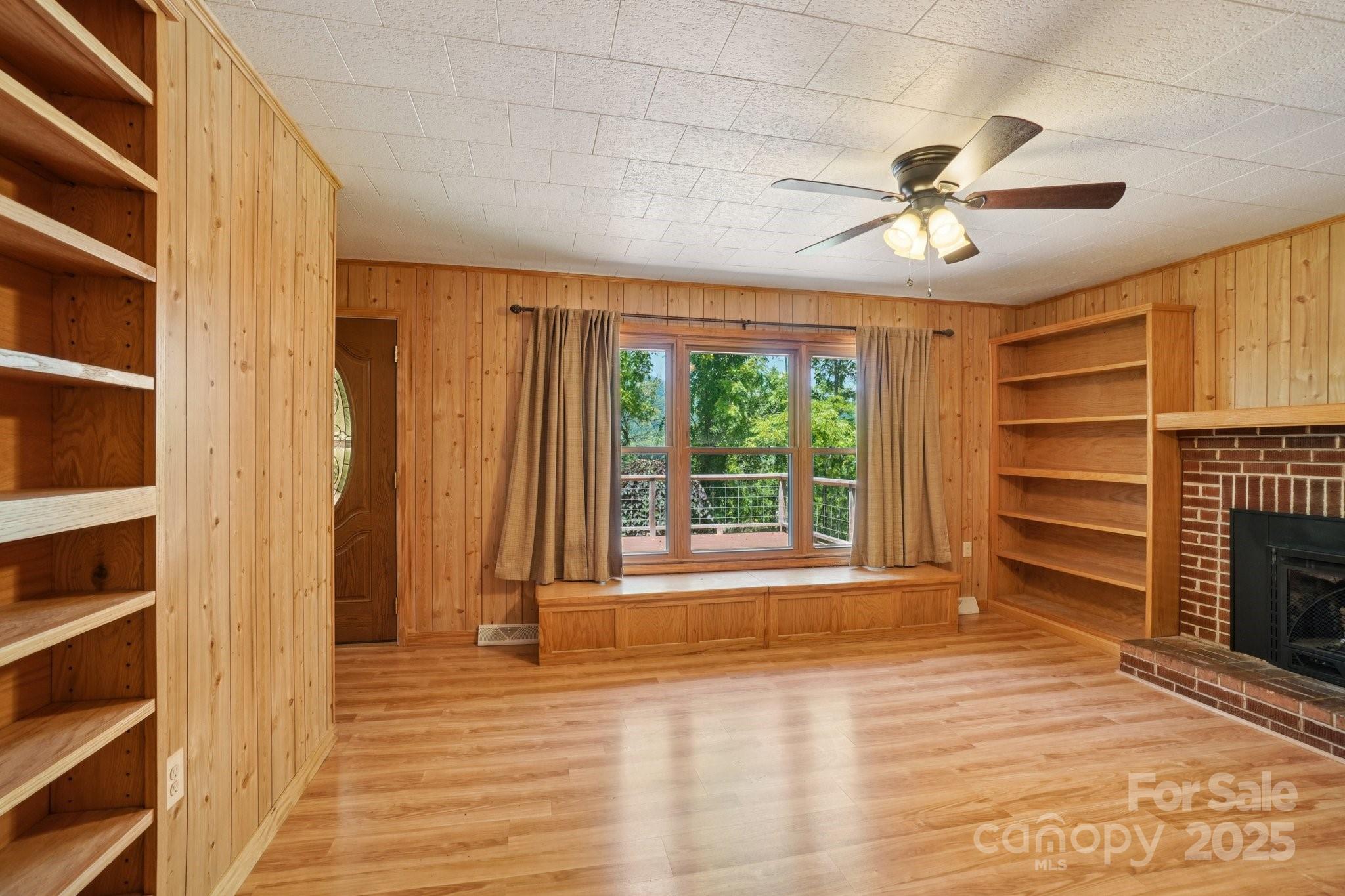 623 Edwards Cove Road Waynesville, NC 28786 - Photo 7 of 46 a view of an empty room with a window and wooden floor