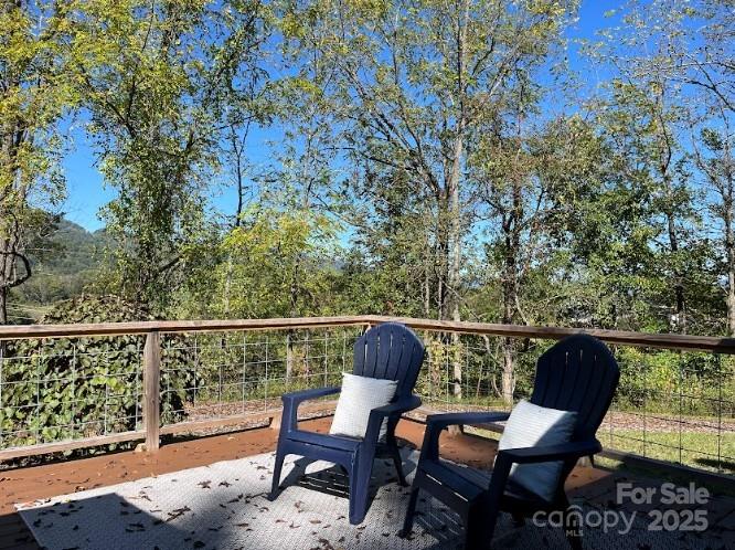 623 Edwards Cove Road Waynesville, NC 28786 - Photo 10 of 46 a balcony with wooden floor table and chairs