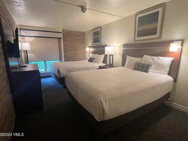 a bed room with two bed and a night stand