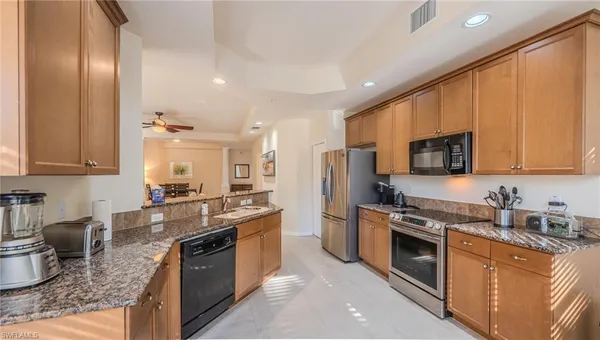 a kitchen with stainless steel appliances granite countertop a stove a sink dishwasher a refrigerator and a microwave