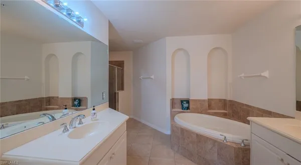 a bathroom with a tub sink and mirror