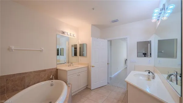 a bathroom with a sink a tub and a mirror