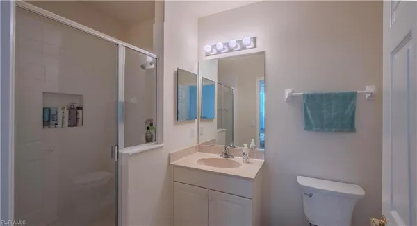 a bathroom with a toilet a sink and mirror