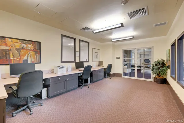 a bedroom with a bed and large windows