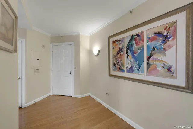 a view of a hallway with wooden floor and a refrigerator