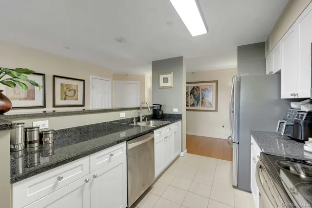 a kitchen with stainless steel appliances granite countertop a sink stove microwave and refrigerator