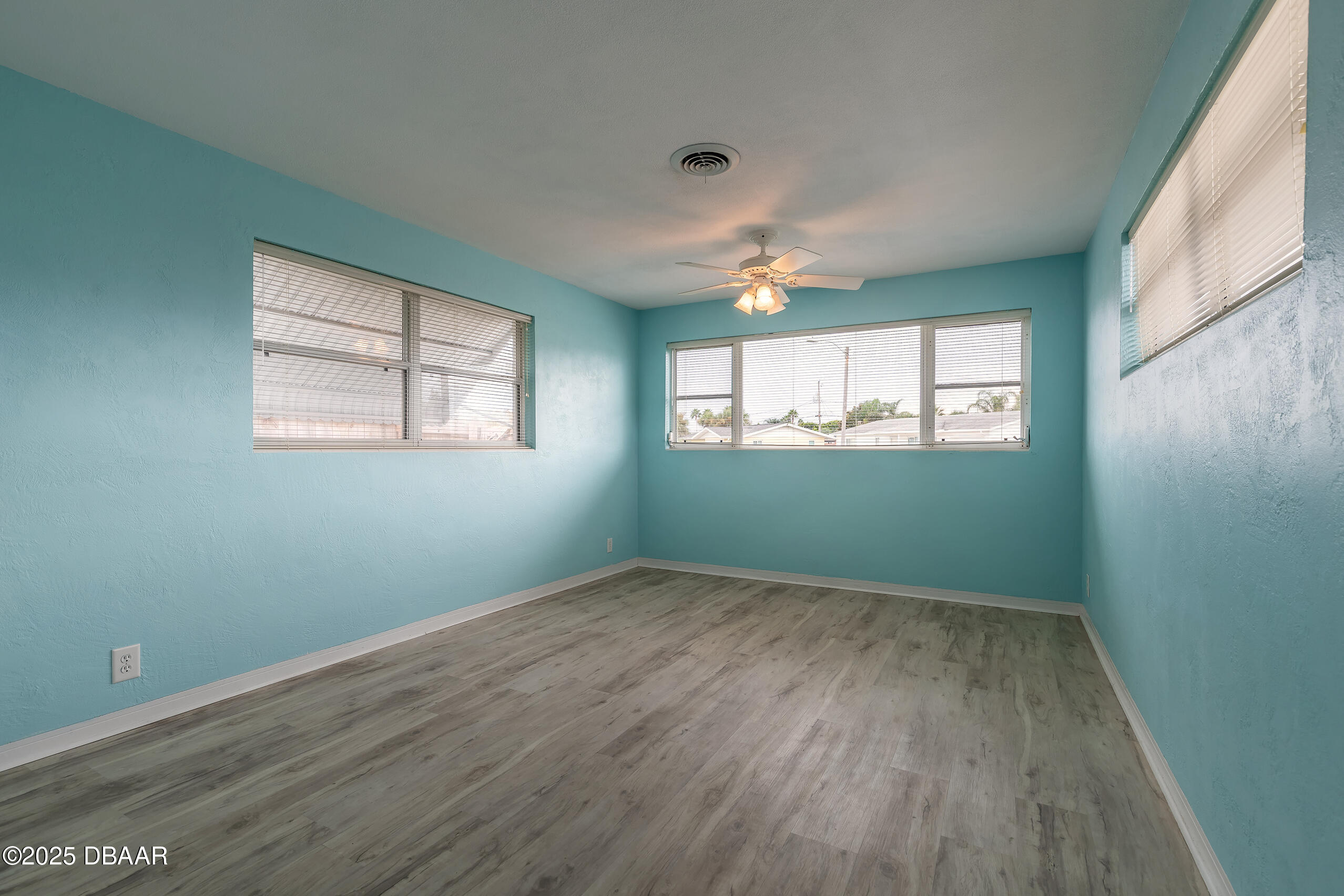 45 Rivocean Drive Ormond Beach, FL 32176 - Photo 4 of 37 an empty room with wooden floor fan and windows