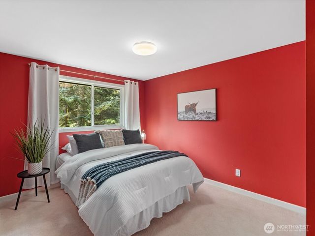 a bedroom with a bed and a large window