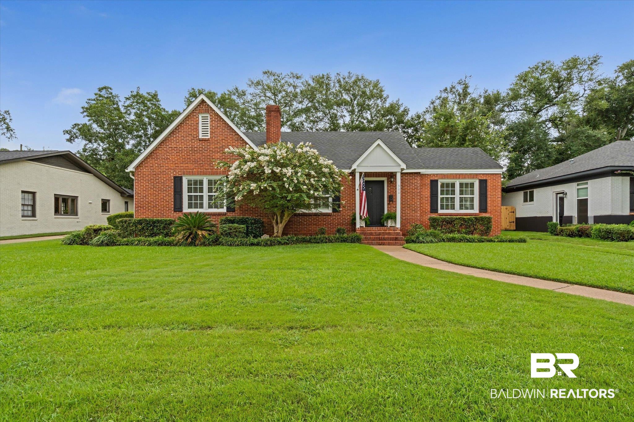 300 Woodlands Avenue Mobile, AL 36607 - Photo 20 of 23 View of front of home with a front lawn, brick siding, and a chimney