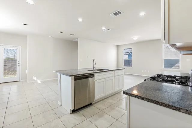a kitchen with granite countertop a sink and a stove