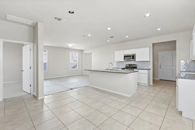 a view of kitchen with white cabinets and refrigerator