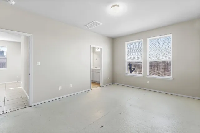 an empty room with windows and closet