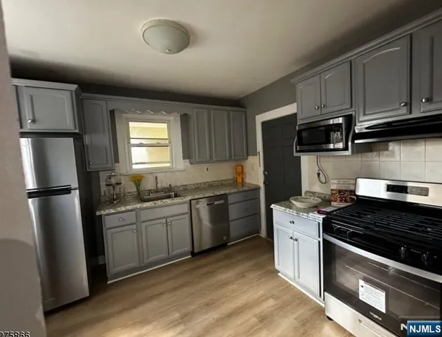 a kitchen with stainless steel appliances granite countertop a stove a refrigerator and a sink