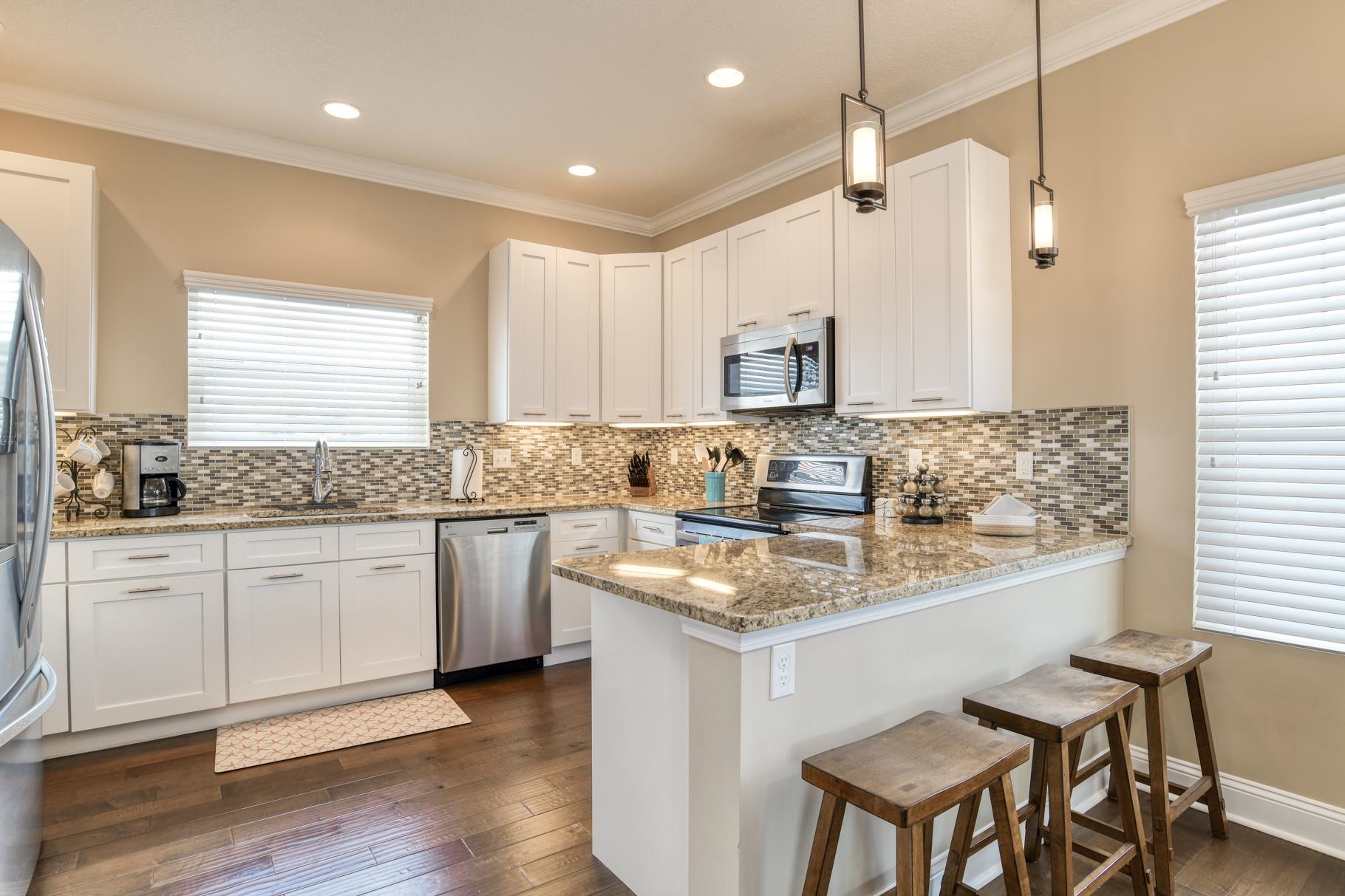 5067 Atlantic View St. Augustine, FL 32080 - Photo 30 of 47 a kitchen with kitchen island granite countertop a sink cabinets and wooden floor