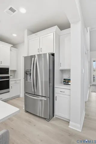a kitchen with stainless steel appliances a refrigerator and a stove top oven