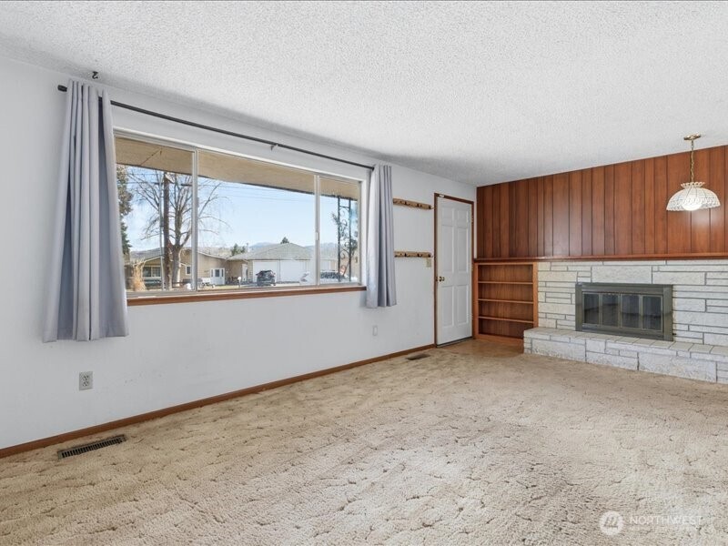 702 West Ridge Drive Omak, WA 98841 - Photo 4 of 26 a view of an empty room with a fireplace and a window