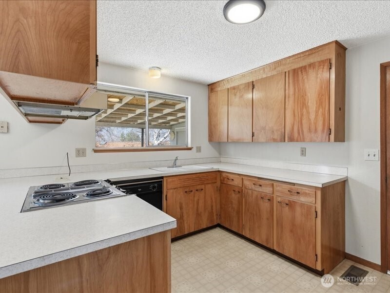 702 West Ridge Drive Omak, WA 98841 - Photo 9 of 26 a kitchen with stainless steel appliances granite countertop a sink stove and cabinets