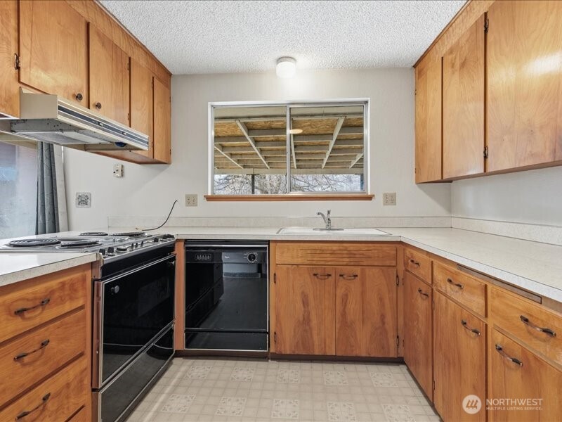 702 West Ridge Drive Omak, WA 98841 - Photo 10 of 26 a kitchen with stainless steel appliances granite countertop a stove and a sink