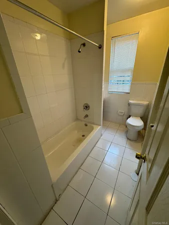 a bathroom with a granite countertop bathtub shower and toilet