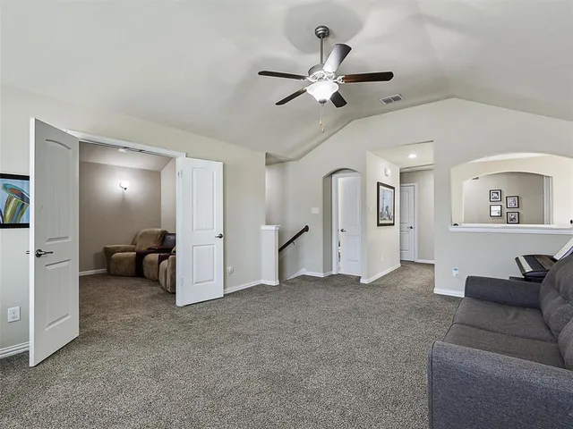 a living room with furniture and a ceiling fan