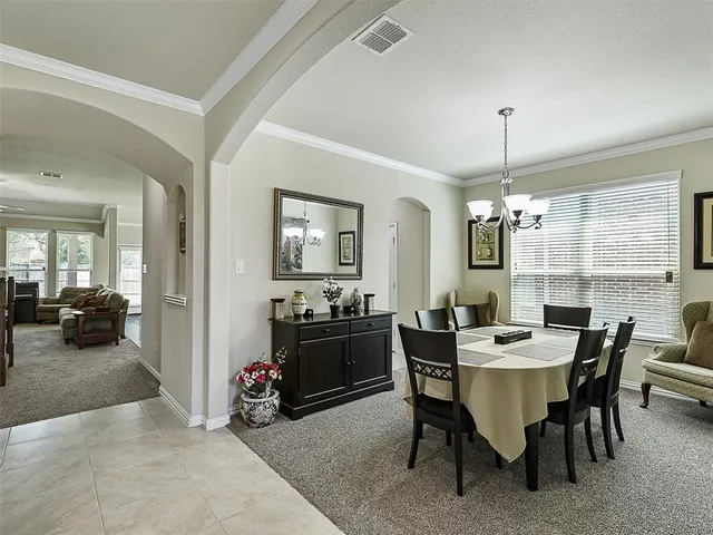 a view of a dining room with furniture and chandelier