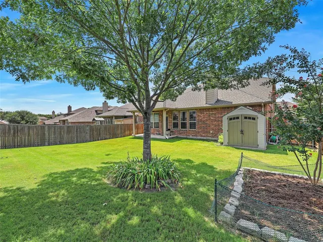 a view of a house with backyard and a tree