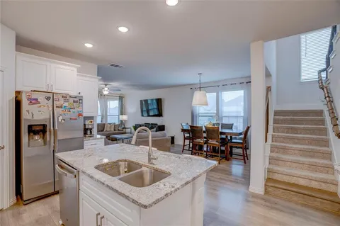 a kitchen with stainless steel appliances granite countertop a sink and a refrigerator