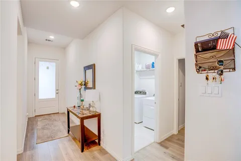 a view of a hallway to a livingroom with furniture and a window