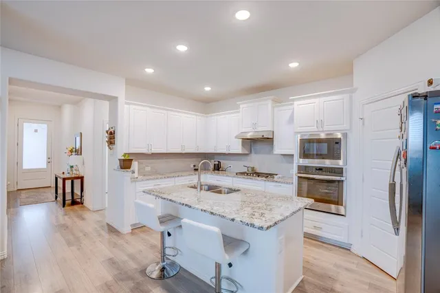 a kitchen with a sink stainless steel appliances and counter space