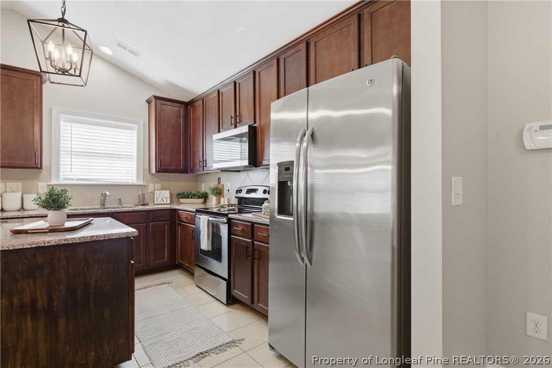 415 Colonist Place Cameron, NC 28326 - Photo 12 of 49 a kitchen with stainless steel appliances granite countertop a refrigerator a sink a stove and dishwasher with wooden floor