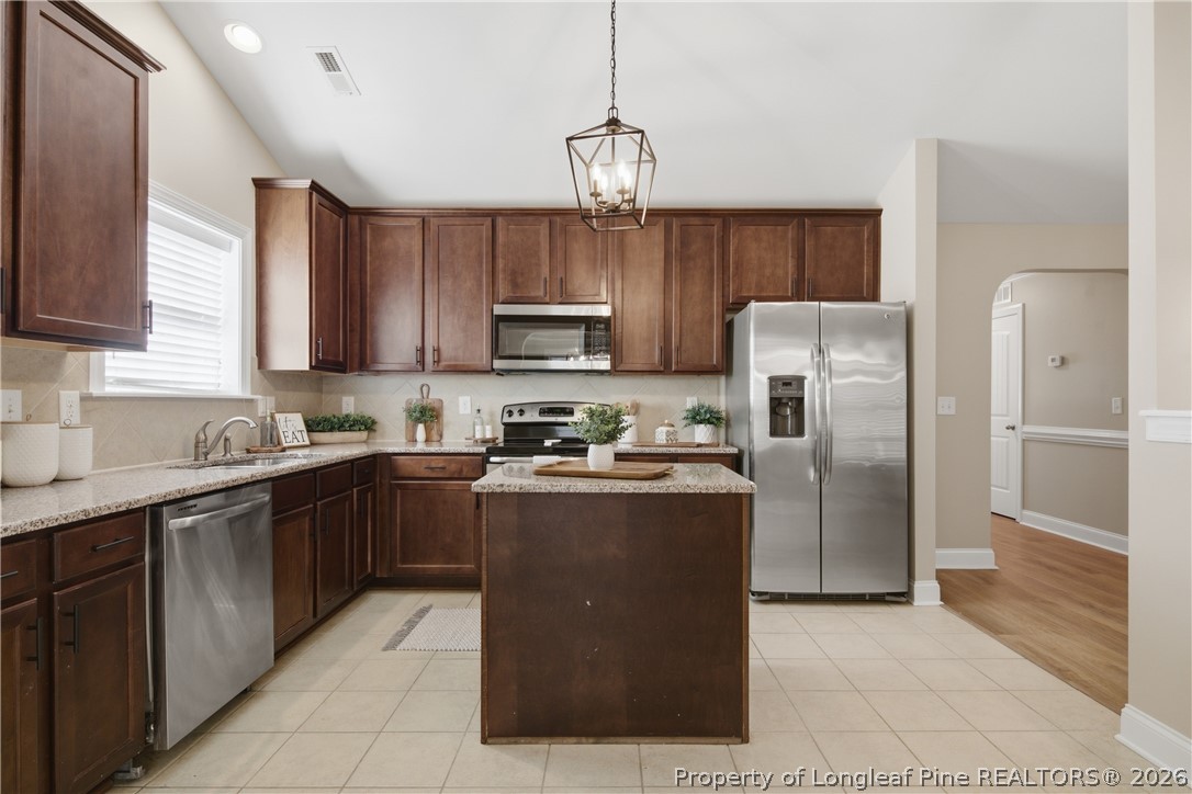 415 Colonist Place Cameron, NC 28326 - Photo 13 of 49 a kitchen with stainless steel appliances granite countertop a refrigerator a sink a stove a microwave and island