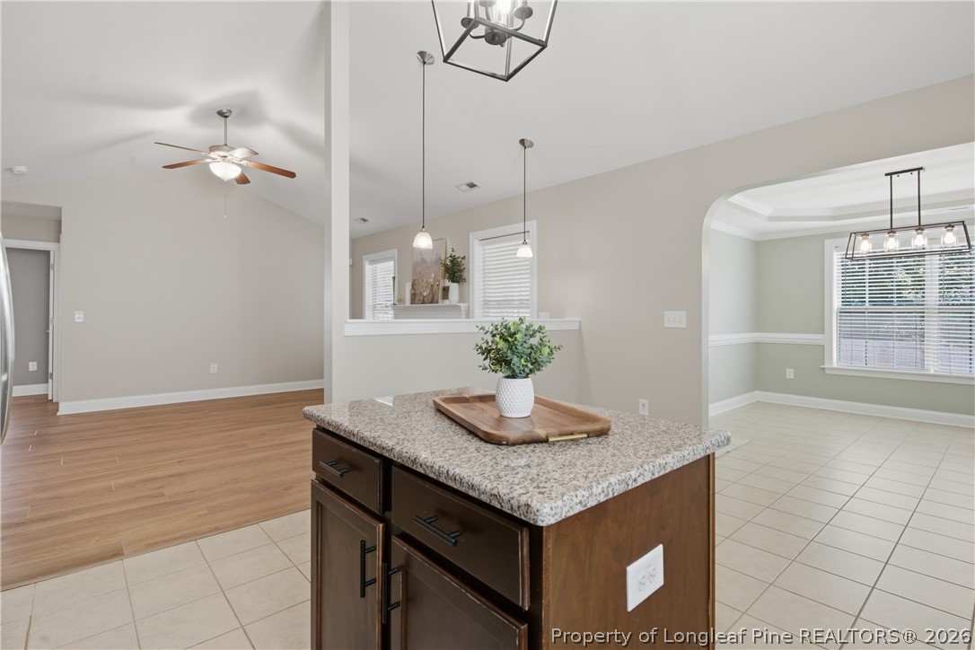 415 Colonist Place Cameron, NC 28326 - Photo 15 of 49 a kitchen with granite countertop a table chairs and wooden floor