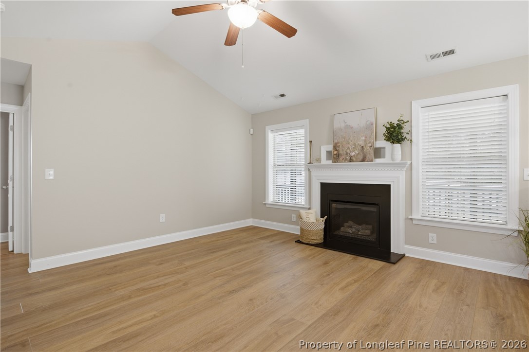 415 Colonist Place Cameron, NC 28326 - Photo 10 of 49 an empty room with windows fireplace and wooden floor