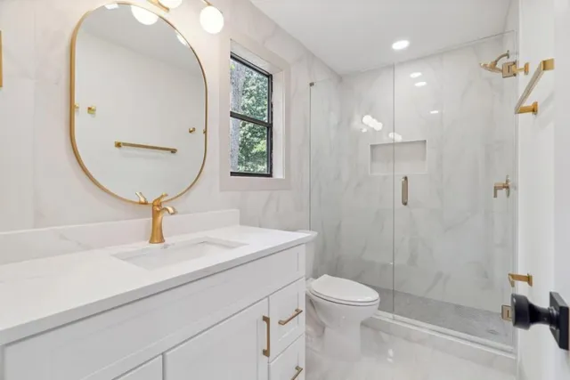 a bathroom with a toilet a sink a mirror and vanity