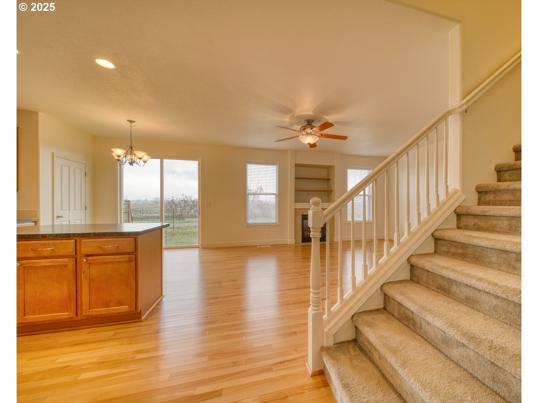 52036 Southeast Icenogle Loop Scappoose, OR 97056 - Photo 15 of 41 a view of staircase and kitchen with wooden floor and seating
