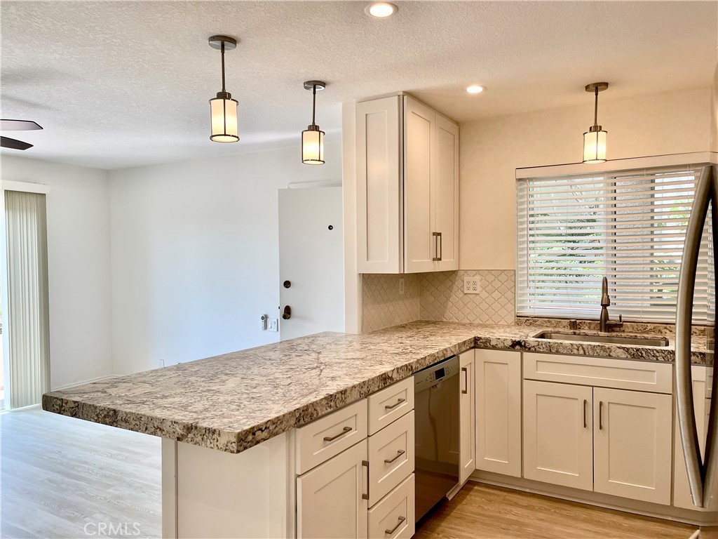 352 Y Place, Unit B Laguna Beach, CA 92651 - Photo 7 of 20 a kitchen with granite countertop a sink cabinets stainless steel appliances and a counter top space