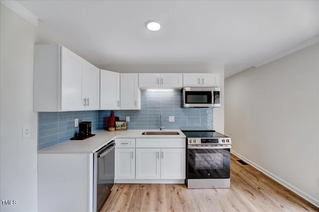 a kitchen with granite countertop a sink and steel appliances