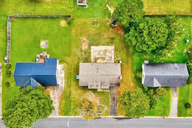a view of a yard in front of a house with large tree