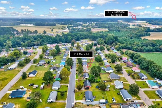 an aerial view of a house with garden space and street view