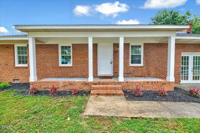 a view of a house with backyard and sitting area