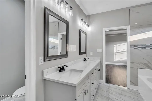 a bathroom with a sink a toilet a vanity and mirror