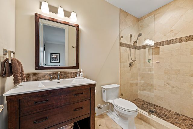 a bathroom with a toilet a sink a mirror and shower