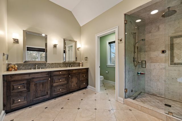 a bathroom with a granite countertop sink mirror and shower