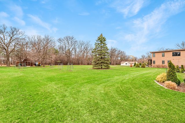 a front view of a house with a yard and that has a lot of windows