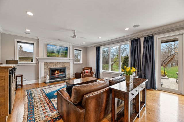 a living room with furniture fireplace and a large window