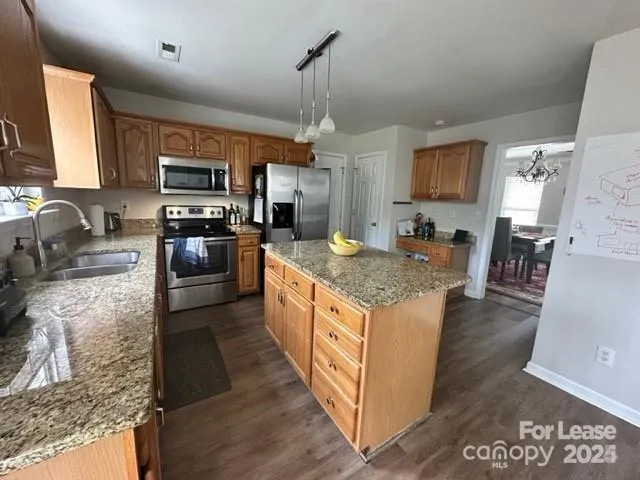 a large kitchen with granite countertop a stove oven and a sink