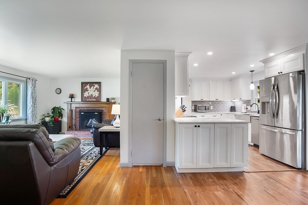407 Wolf Swamp Road Longmeadow, MA 01106 - Photo 11 of 42 a living room with furniture a fireplace and a kitchen view