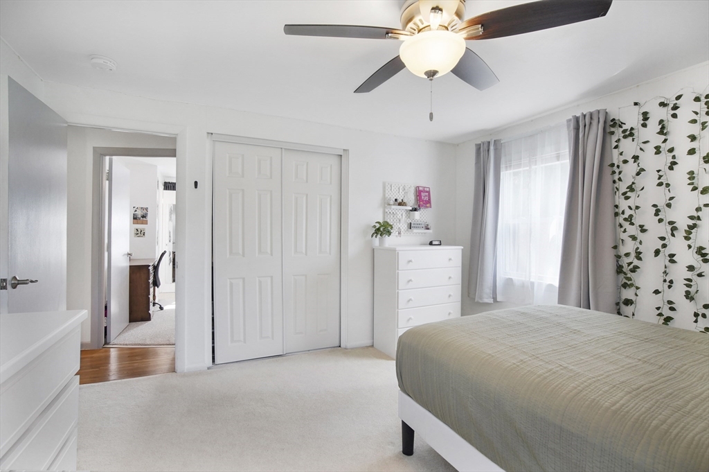 407 Wolf Swamp Road Longmeadow, MA 01106 - Photo 22 of 42 a bedroom with a bed and a chandelier