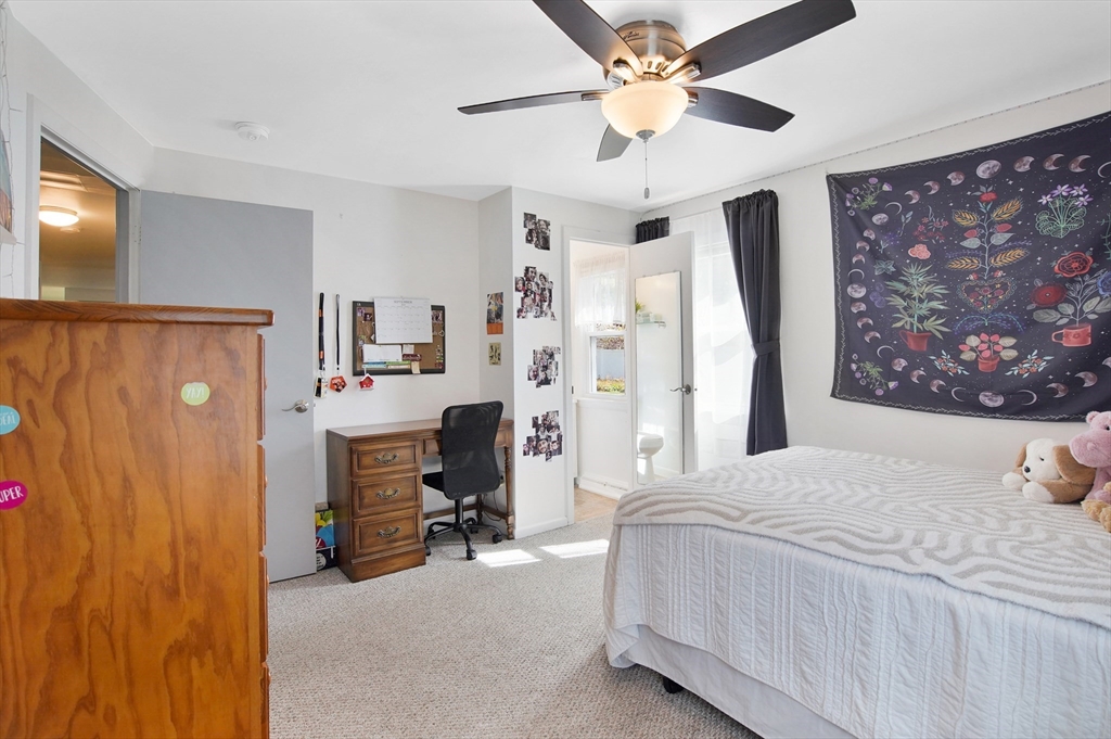 407 Wolf Swamp Road Longmeadow, MA 01106 - Photo 24 of 42 a bedroom with a bed and a chandelier