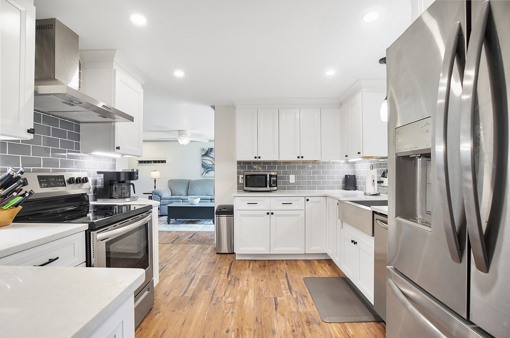 407 Wolf Swamp Road Longmeadow, MA 01106 - Photo 5 of 42 a kitchen with white cabinets and stainless steel appliances